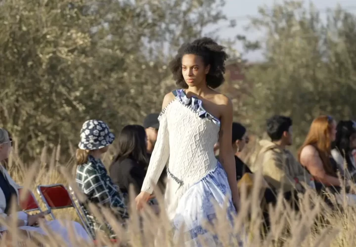 A model walking outside amongst plants and trees with people watching as part of our video production Marlow services